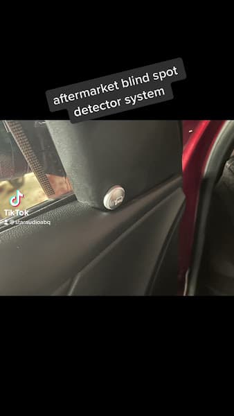 Video still of a blind spot detector button in a car door at Star Audio #2 in Albuquerque, New Mexico