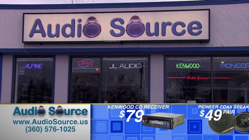 Storefront with lit sign and brand window decals at Audio Source in Vancouver, Washington