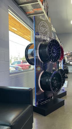 Display tower of wheels beside a window and black bench at Sounds Fast in Bend, Oregon