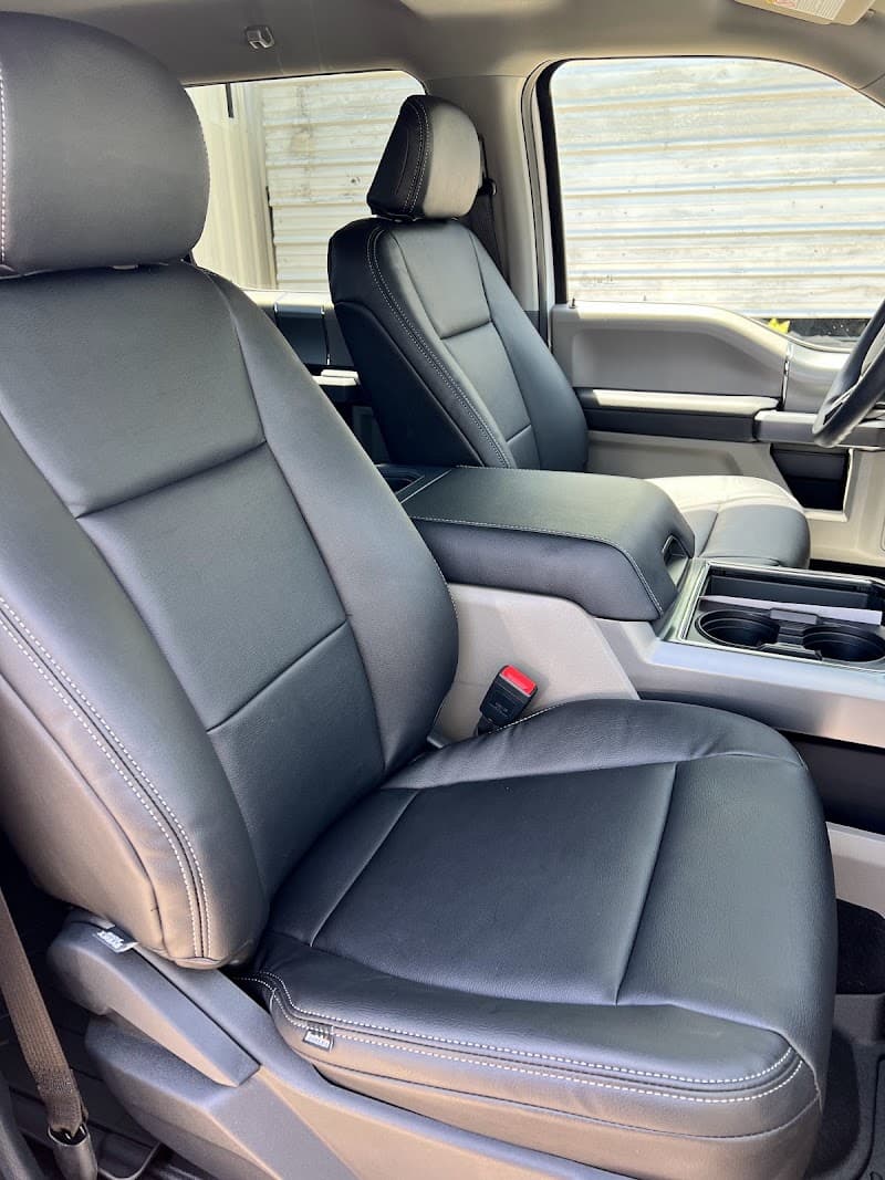 Black leather front seats in a pickup truck interior at Motion Audio & OffRoad in Orange, Texas
