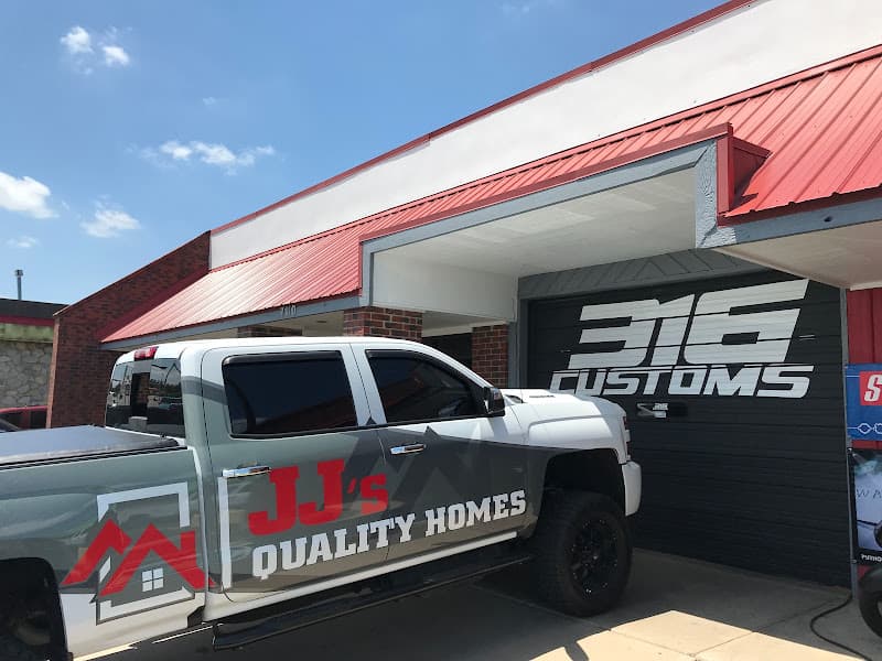 Storefront with red metal roof, black bay door and parked pickup at 316 CUSTOMS in Wichita, Kansas
