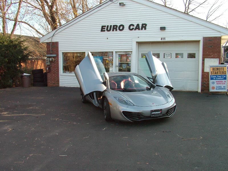 Silver McLaren sports car with doors raised in front of garage at Euro Car in Red Bank, New Jersey