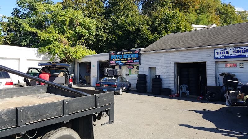 Garage storefront with Auto Sound sign beside a tire shop at J.J. Audio in Danbury, Connecticut