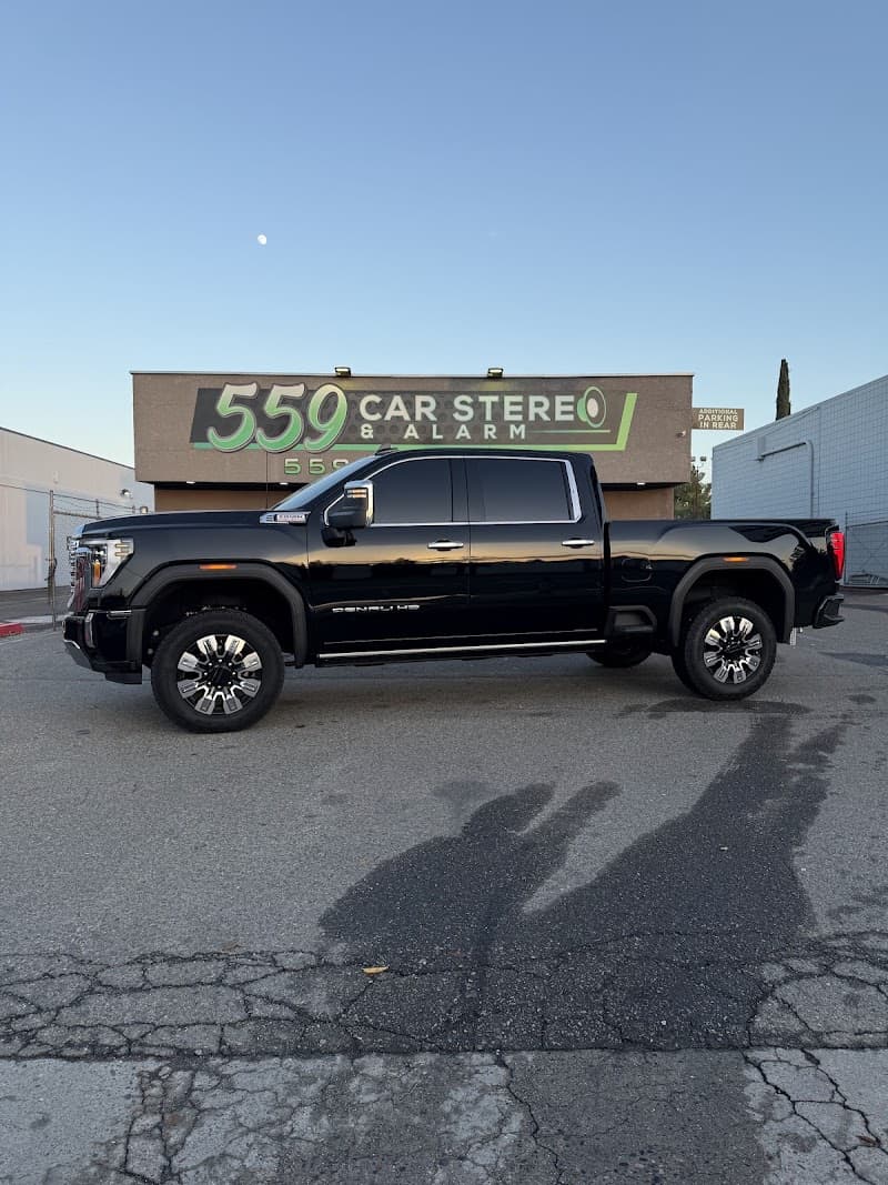 Black pickup truck parked in front of storefront sign at 559 Car Stereo & Alarm in Fresno, California