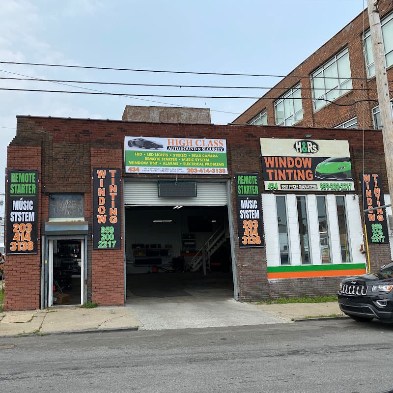 Brick shop front with bay door and window tinting signs at High class auto sound & security in Bridgeport, Connecticut