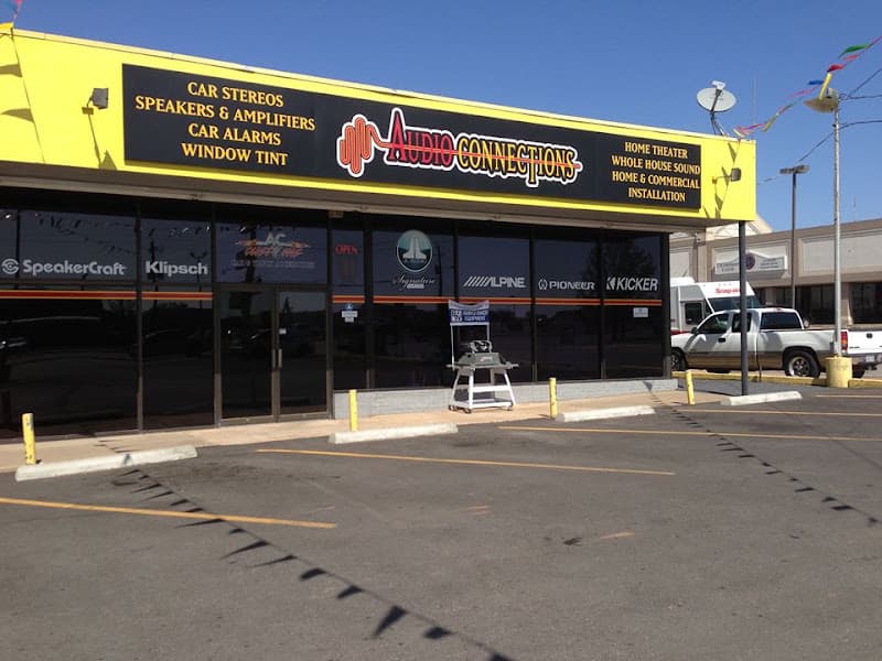 Yellow storefront with car audio brand decals in windows at Audio Connections / AC Customs in Wichita Falls, Texas