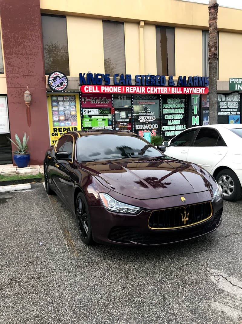 Maroon Maserati sedan parked outside a car stereo storefront at Kings Car Stereo & Alarms in Houston, Texas