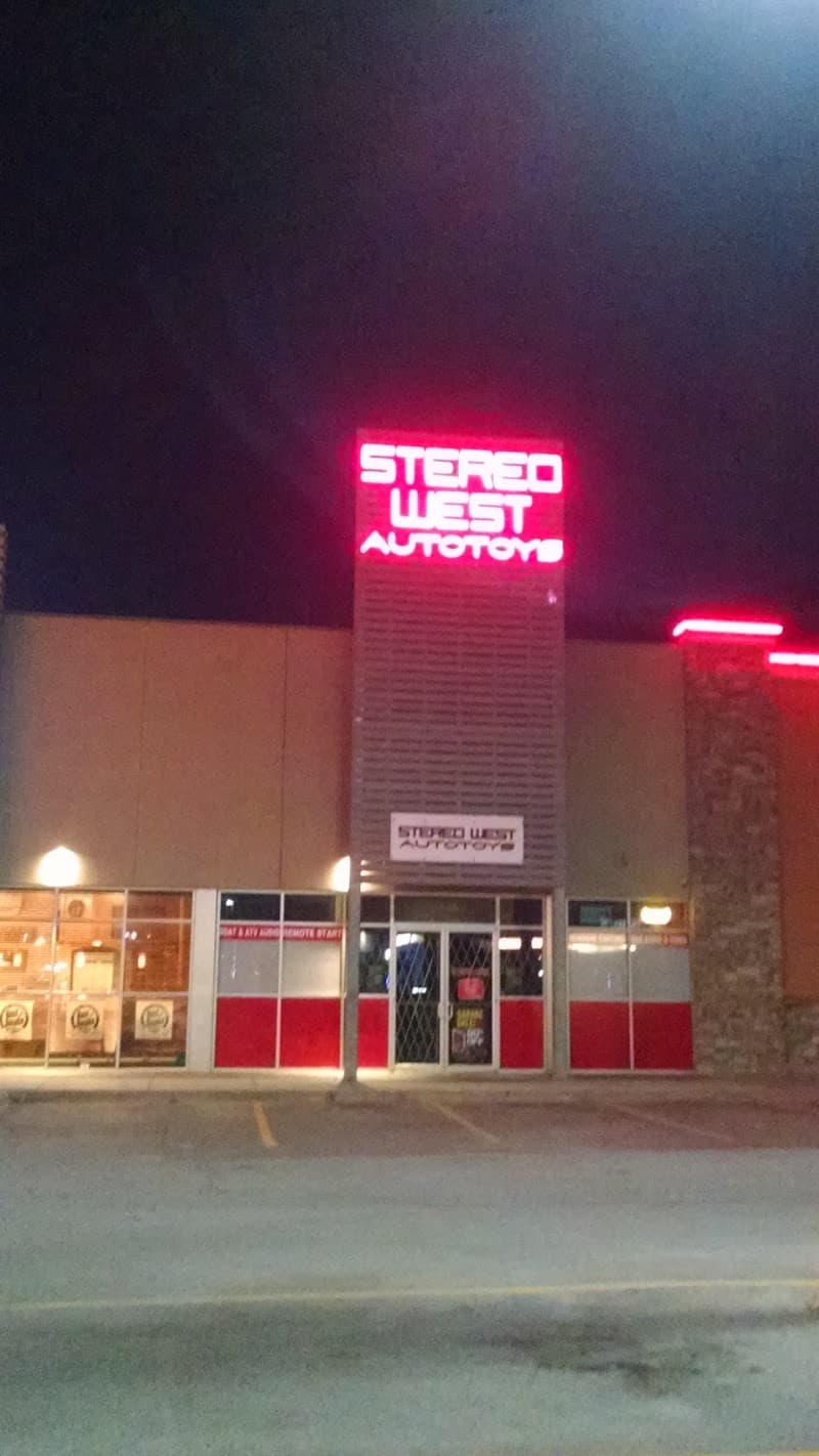 Night view of storefront with lit red tower sign at Stereo West Autotoys in Omaha, Nebraska