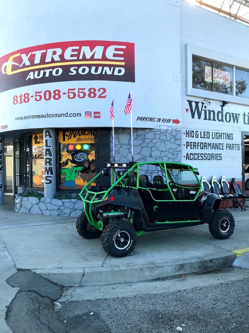 Green and black off-road vehicle parked outside a storefront at Extreme Auto Sound in North Hollywood, California