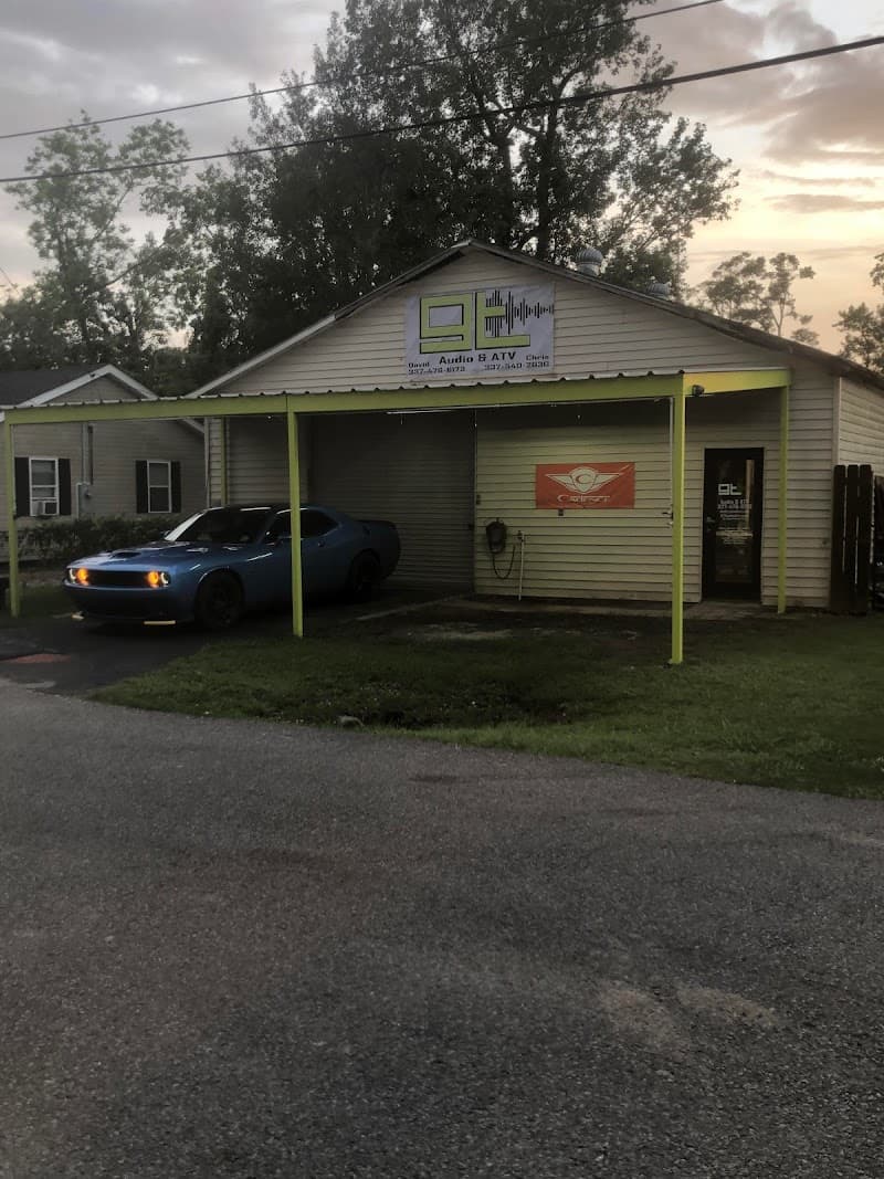 Blue coupe parked under a green-trimmed carport at GT Audio in Sulphur, Louisiana