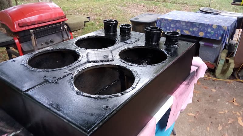 Black enclosure with four round speaker holes outdoors at Bass Brother's Car Audio in Clarksville, Tennessee