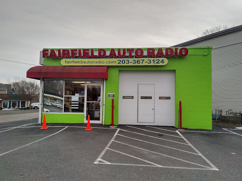 Green storefront with red sign and white garage door at Fairfield Auto Radio in Fairfield, Connecticut