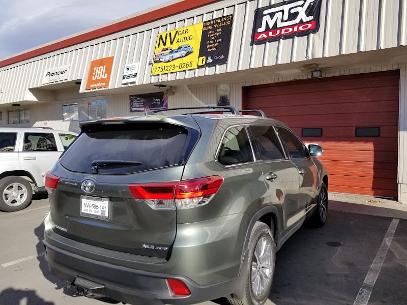 Gray Toyota SUV parked in front of shop with red bay door at NV Car Audio in Reno, Nevada