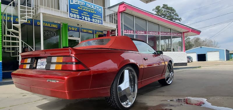 Red convertible with chrome wheels parked outside at DEEP SOUTH AUDIO AND TINT in Amite City, Louisiana