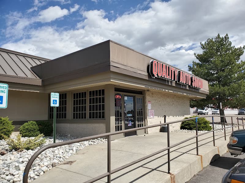 Tan storefront with red sign and accessible parking sign at Quality Auto Sound in Aurora, Colorado