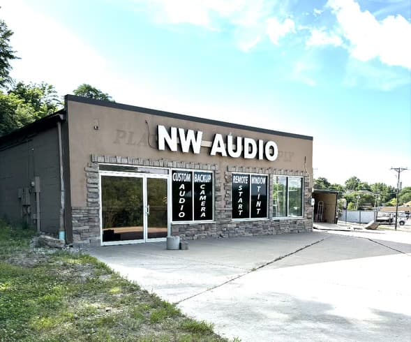Tan storefront with stone base and large white sign at NW Audio in Platte City, Missouri
