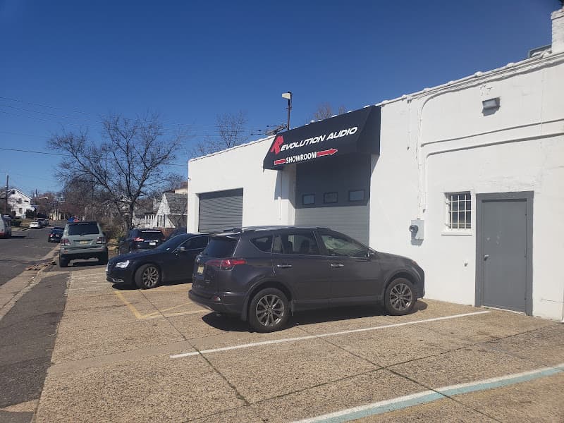 White building with showroom sign and SUVs parked out front at Revolution Audio in Pennsauken Township, New Jersey