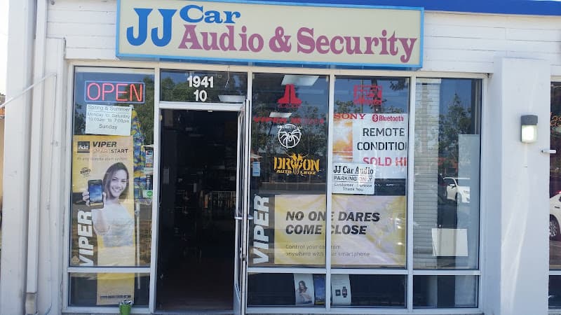 Storefront with red OPEN sign and window decals at JJ Car Audio & Security in San Jose, California