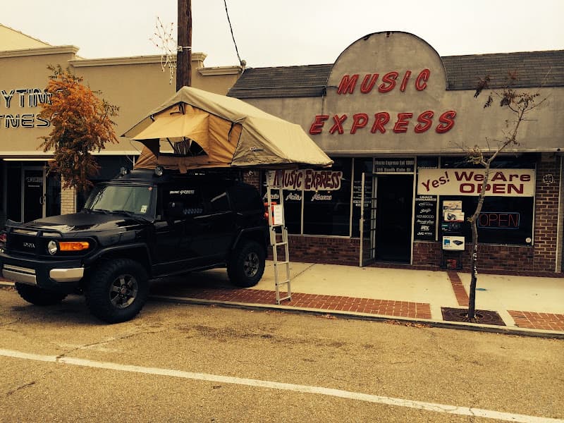 Black SUV with rooftop tent parked outside storefront at Music Express Car Audio in Hammond, Louisiana