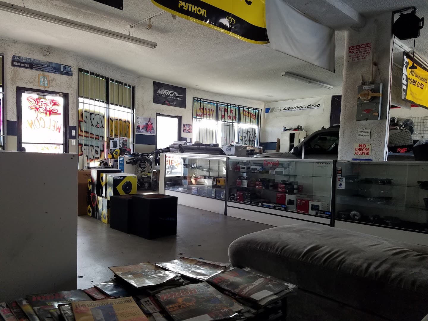 Shop interior with glass display cases, speakers and Python banner at 310 Kreations in Gardena, California