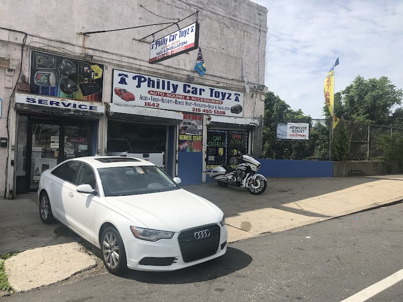 White Audi sedan parked outside a storefront with signs at philly car toyz in Philadelphia, Pennsylvania