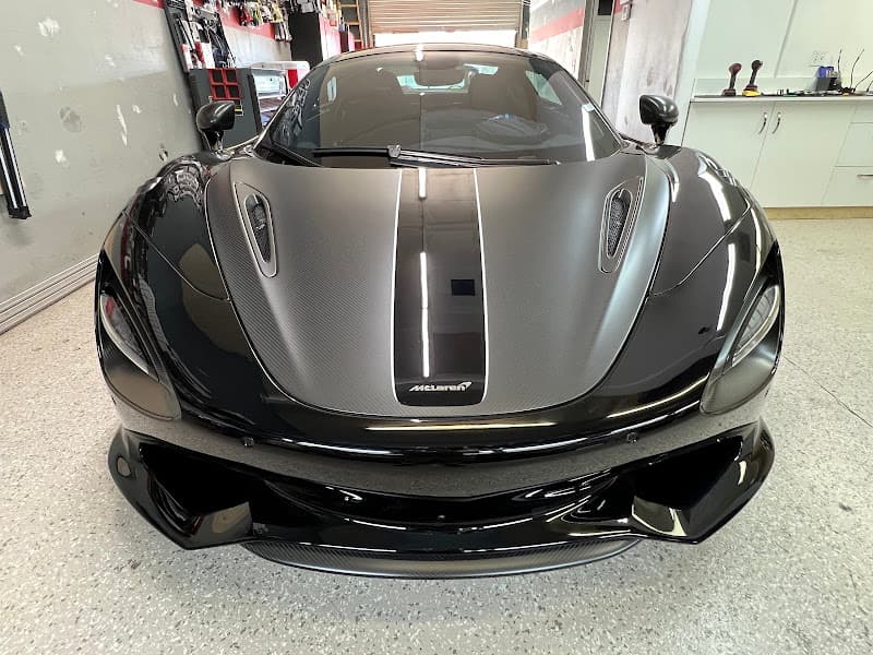 Black McLaren sports car with matte hood stripe, front view at Audio Car LLC in Palm Desert, California
