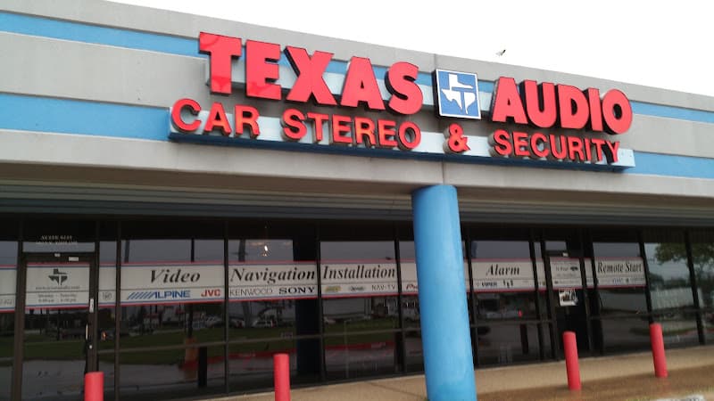 Storefront with red sign letters and a blue pillar at Texas Audio Car Stereo & Security in Garland, Texas