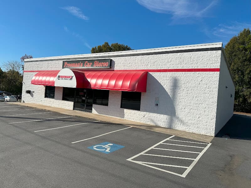 White brick storefront with red awning and red sign at Freeman's Car Stereo in Concord, North Carolina