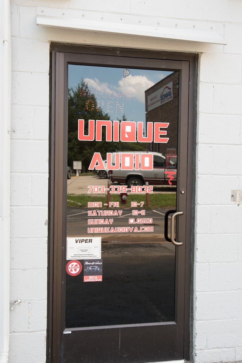 Glass front door with Unique Audio window lettering and hours at Unique Audio in Lorton, Virginia