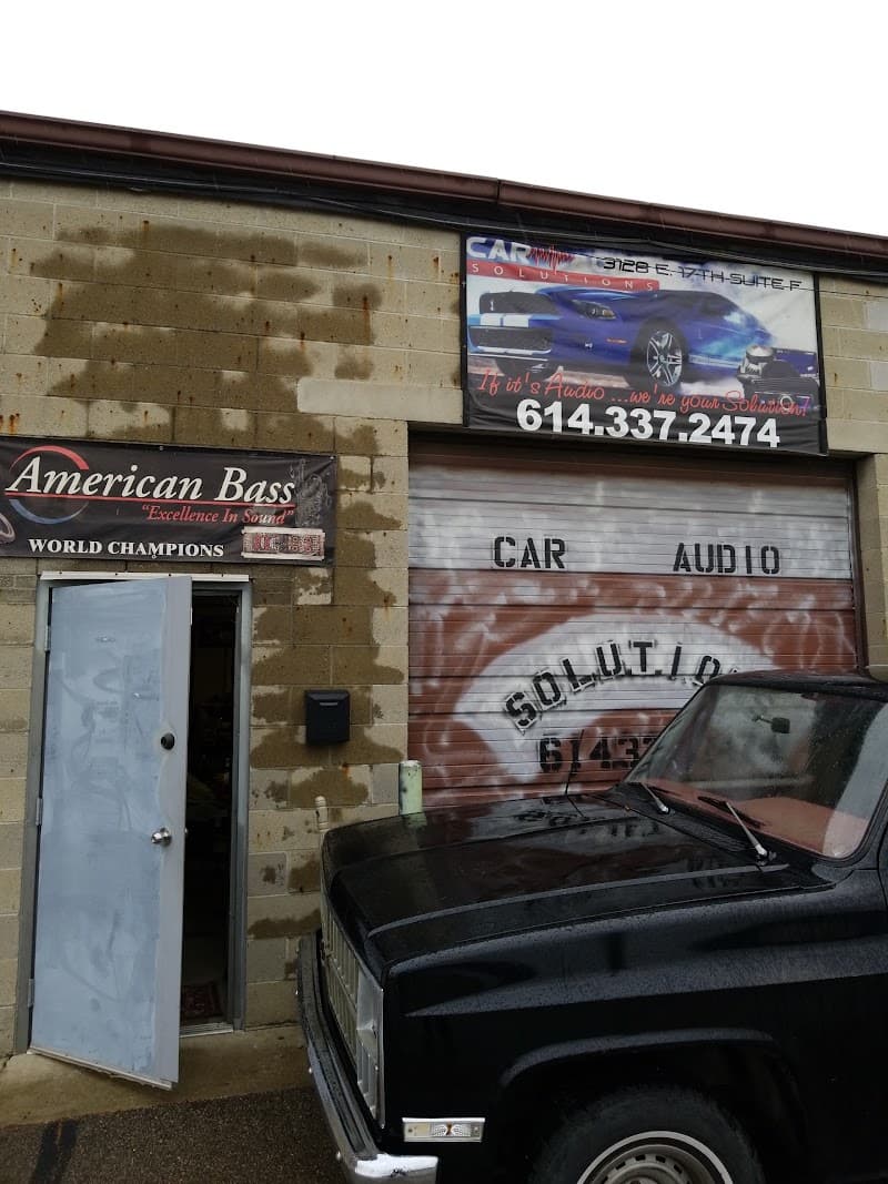 Storefront with garage door and black pickup truck at Car Audio Solutions LLC in Columbus, Ohio