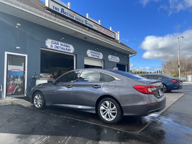 Gray sedan beside the car wash and tinting bays at Action Audio Store LLC in Hartford, Connecticut
