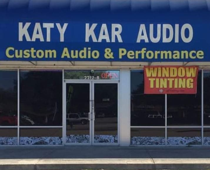 Storefront with blue awning sign and window tinting banner at Katy Kar Audio in Houston, Texas