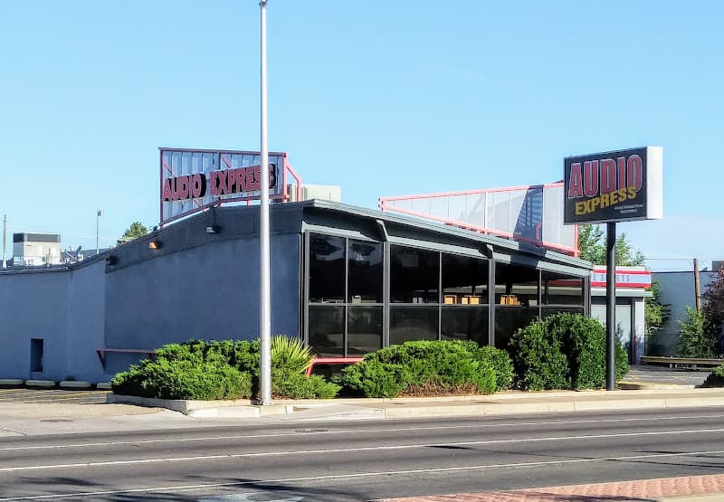 Single-story gray storefront with rooftop sign and pole sign at Audio Express in Albuquerque, New Mexico