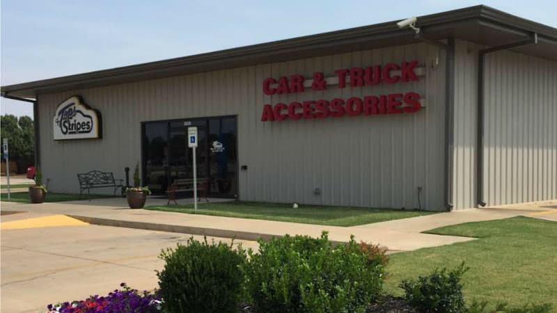 Beige metal building with red Car & Truck Accessories sign at Tops & Stripes Inc. in Enid, Oklahoma