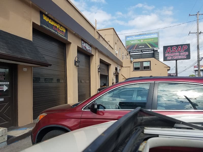 Tan building with garage doors and a parked red SUV at ASAP Car stereo & Remote starters in Norristown, Pennsylvania