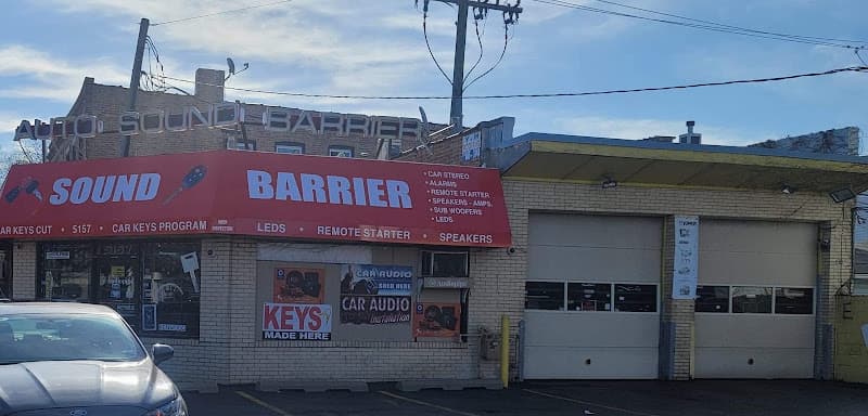 Storefront with red sign and two roll-up bay doors at Auto Sound Barrier in Chicago, Illinois