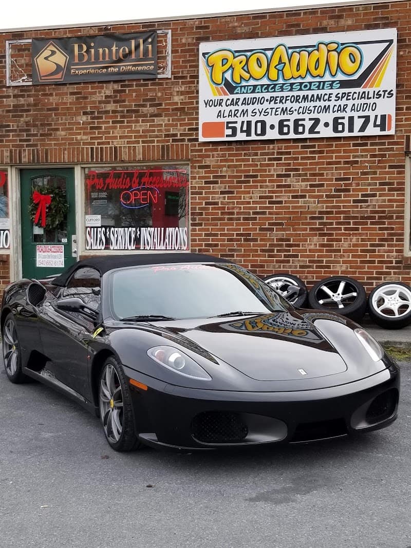 Black convertible sports car parked outside a brick shop front at Pro Audio & Accessories in Winchester, Virginia