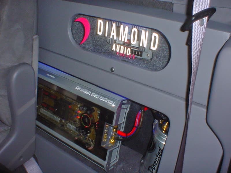 Lit Diamond Audio logo above an amplifier in a car panel at Quality Car Stereo in Pensacola, Florida