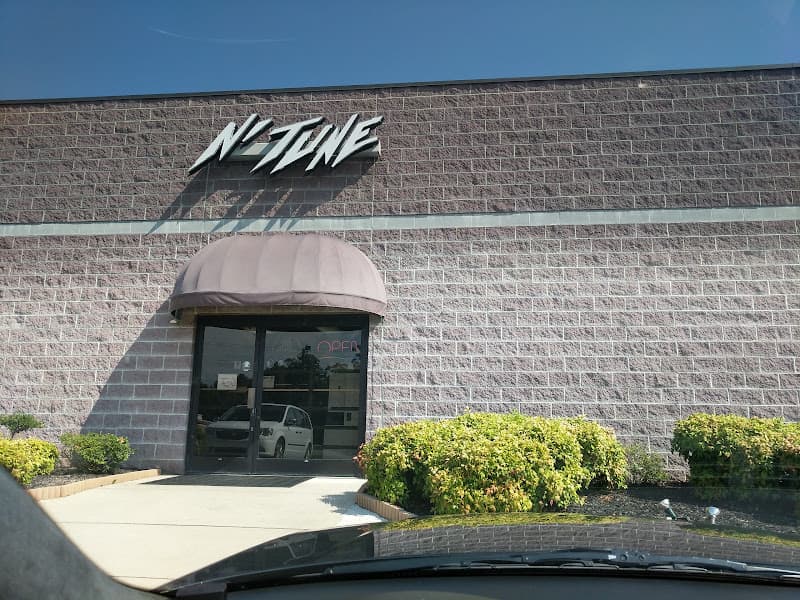 Brick storefront with arched awning and wall sign at N'Tune Car Stereo Inc in Salisbury, North Carolina