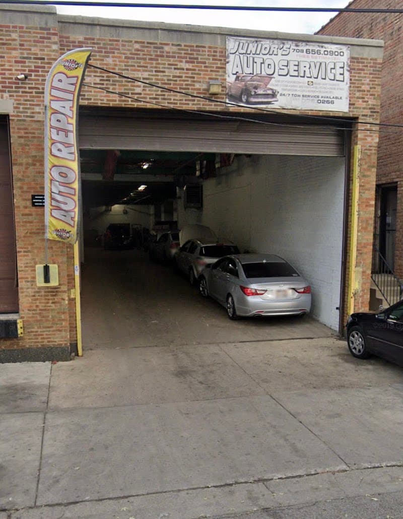 Brick auto repair garage with open bay and parked cars at Beast Sound Installations in Cicero, Illinois