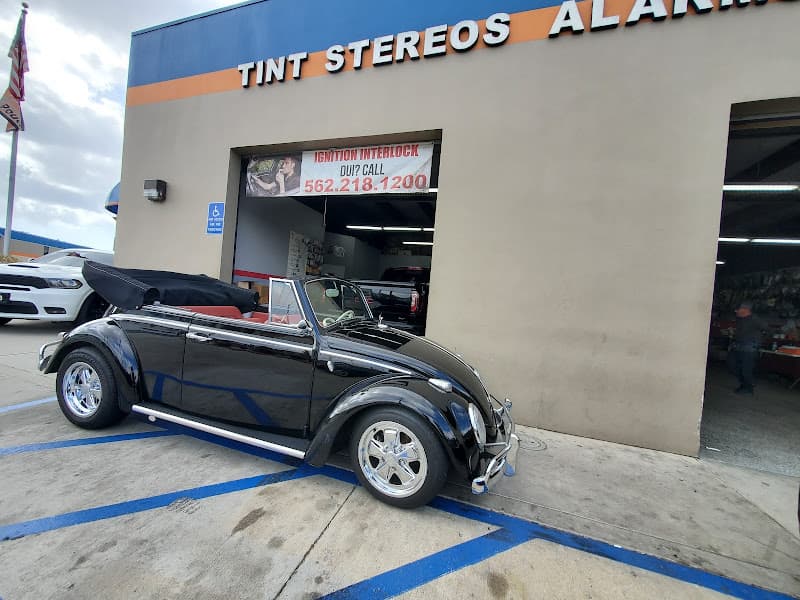 Black classic convertible parked in front of shop building at Long Beach Audio Shop in Long Beach, California