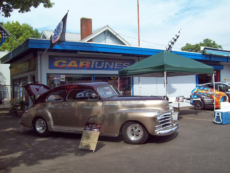 Tan classic coupe parked outside a shop with blue trim at Brad's Car Tunes in Eugene, Oregon