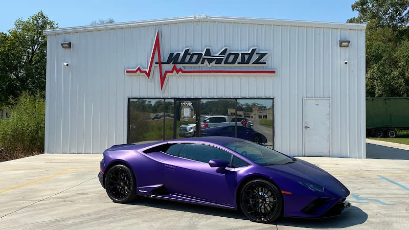 Matte purple sports coupe parked in front of a metal building at AutoModz in Prairieville, Louisiana