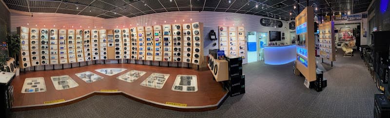 Wide showroom with speaker displays along curved wall at Safe & Sound Mobile Electronics in Manassas, Virginia
