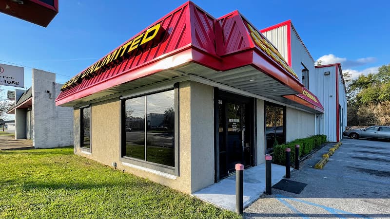 Storefront with red metal roof and yellow sign at Audio Unlimited in Mobile, Alabama