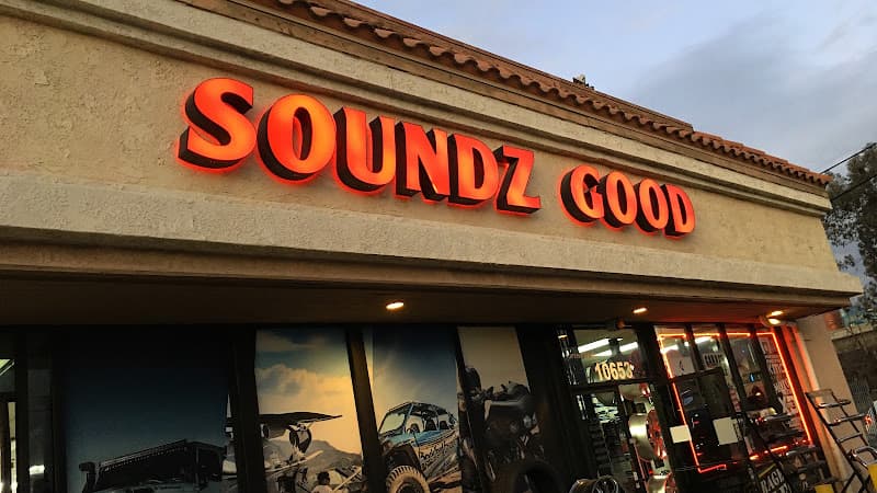 Red lit sign reading SOUNDZ GOOD above a stucco storefront at Soundz Good Garage in Norwalk, California