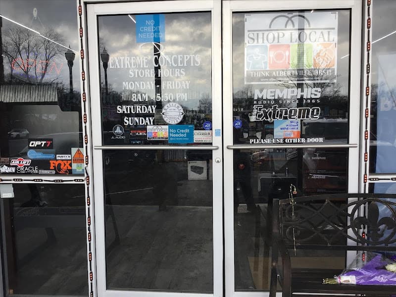 Glass entry doors with store hours and No Credit Needed decals at Extreme Concepts in Albertville, Alabama