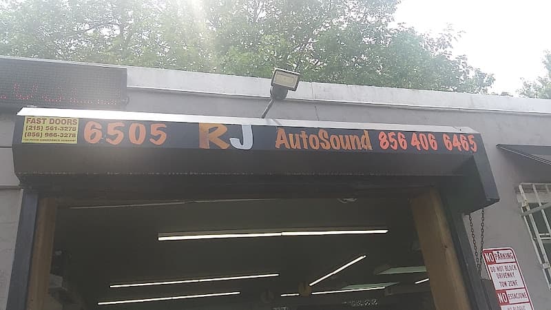 Sign reading RJ AutoSound above a roll-up garage door at RJ AutoSound & Tint in Pennsauken Township, New Jersey