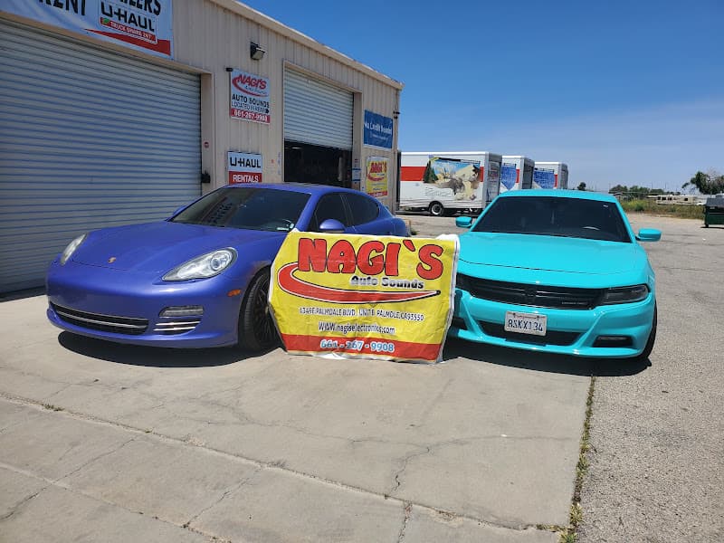 Blue and teal sedans parked beside a yellow banner sign at Nagi's Auto Sound in Palmdale, California