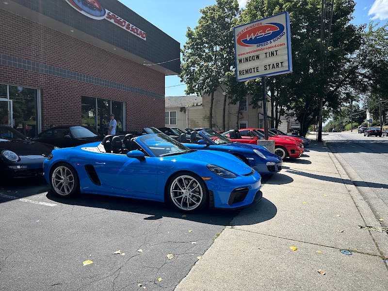 Blue convertible and cars parked outside brick building at Westminster Speed and Sound in Westminster, Maryland